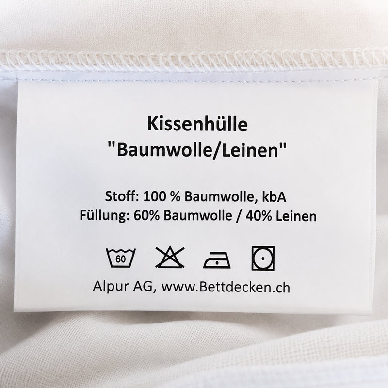Schutzhuelle_Pflege - hirsekissen.ch Care label on a white pillowcase: 100% cotton (kbA) with 60% cotton/40% linen filling; includes washing symbols and supplier info (Alpur AG, bettdecken.ch)